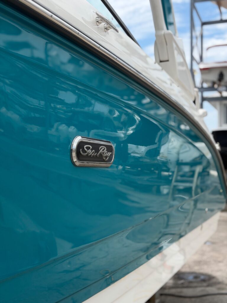 Glossy teal gelcoat hull after professional boat detailing in Sarasota, FL